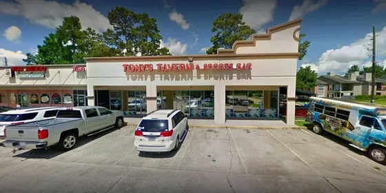The exterior of Tony's Tavern, a single-storey bar with cars parked outside.