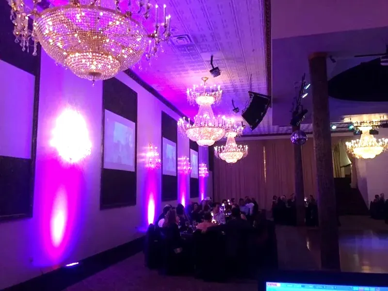 Coloured uplighting along the walls of an event space.
